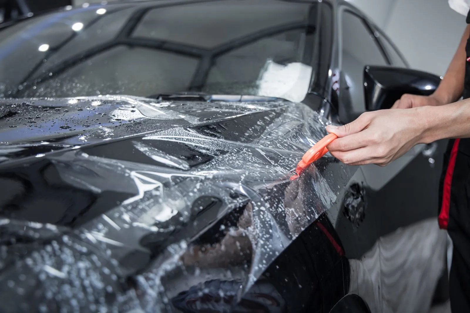 Paint protection film being installed on a hood